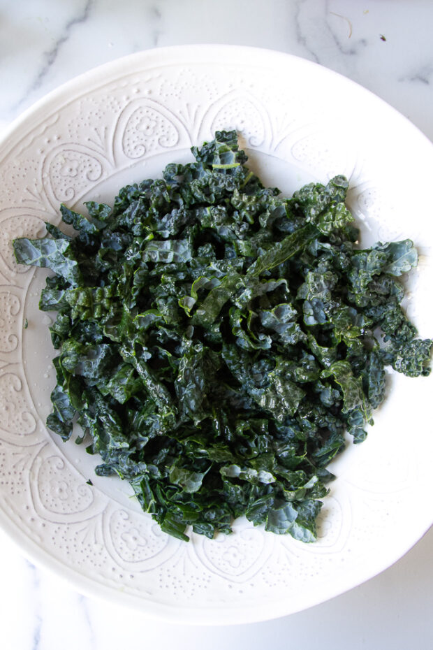 Sliced lacinato kale in a large salad bowl.