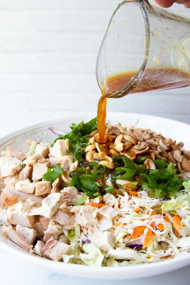 Pouring the ginger dressing over the salad.