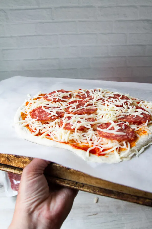 Parchment with the pizza on an inverted baking sheet.