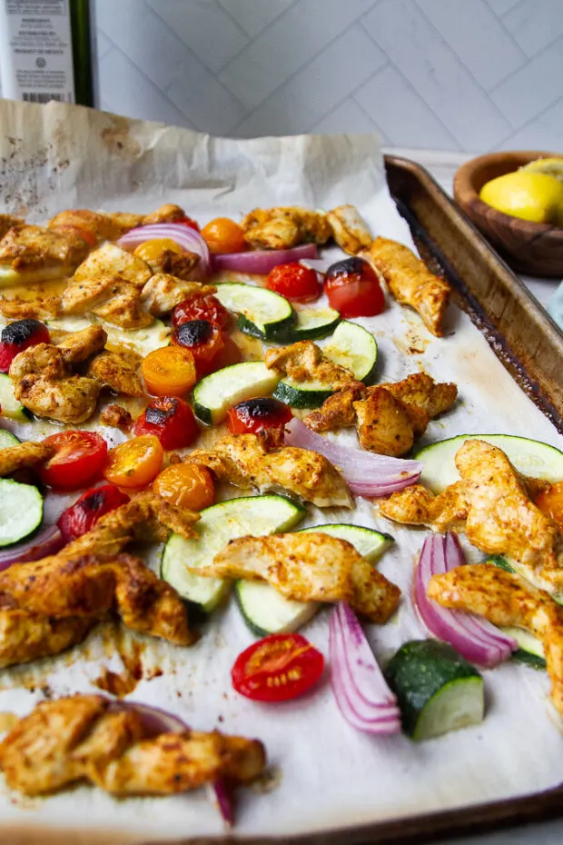 Sheet pan with roasted chicken and vegetables.