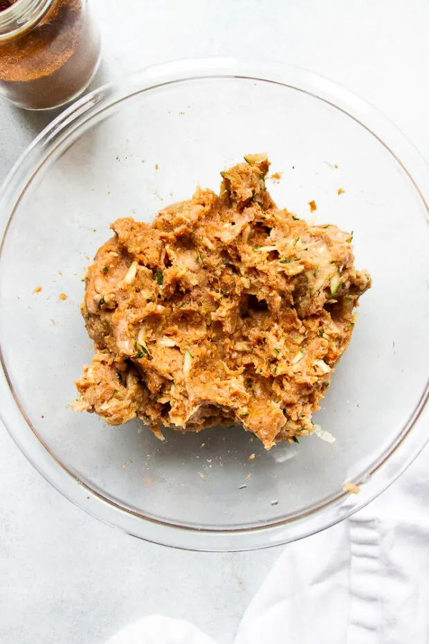 Glass bowl with the ingredients incorporated into the ground turkey. 