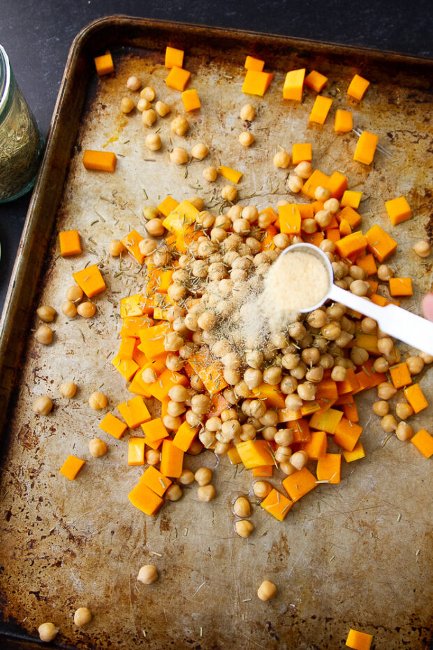 Same shot of the sheet pan with garlic sprinkled on the squash and chickpeas.