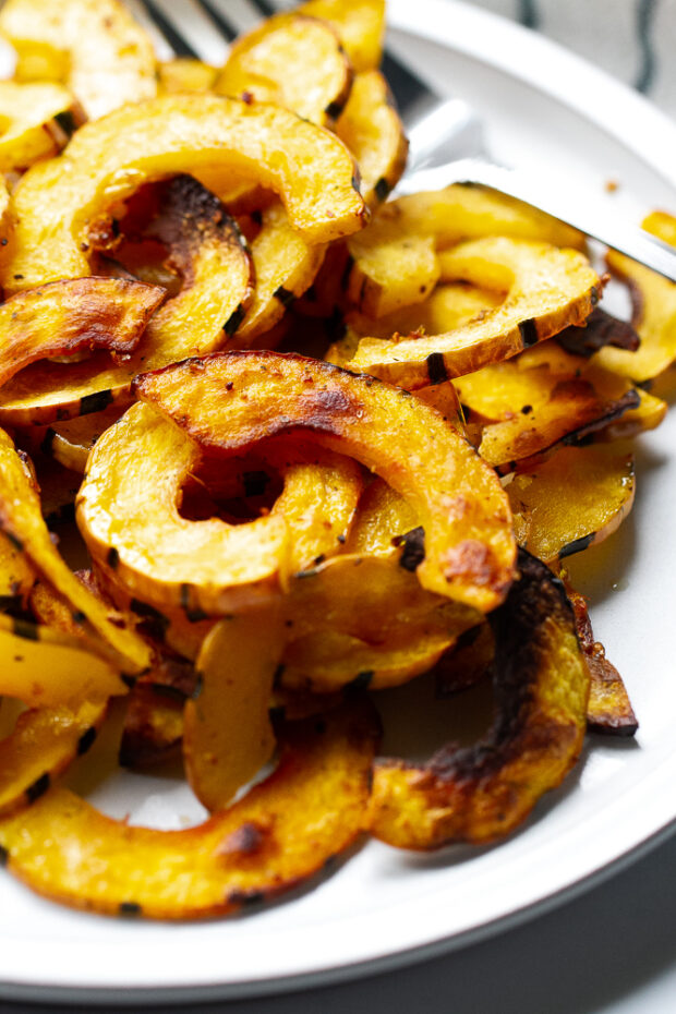 Roasted delicata squash close up view on a serving dish.