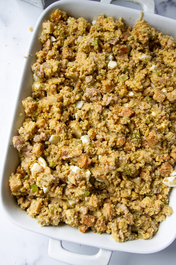 Dressing after chicken broth has been added -- transferred to a large white baking dish and ready for the oven. 