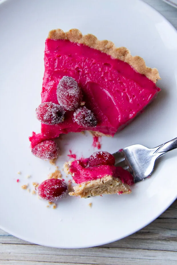 A sliced of the finished cranberry tart with a fork bite taken out.